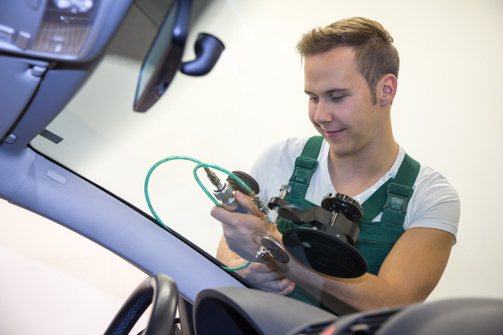 Glazier repairing stone-chipping damage on car's windshield